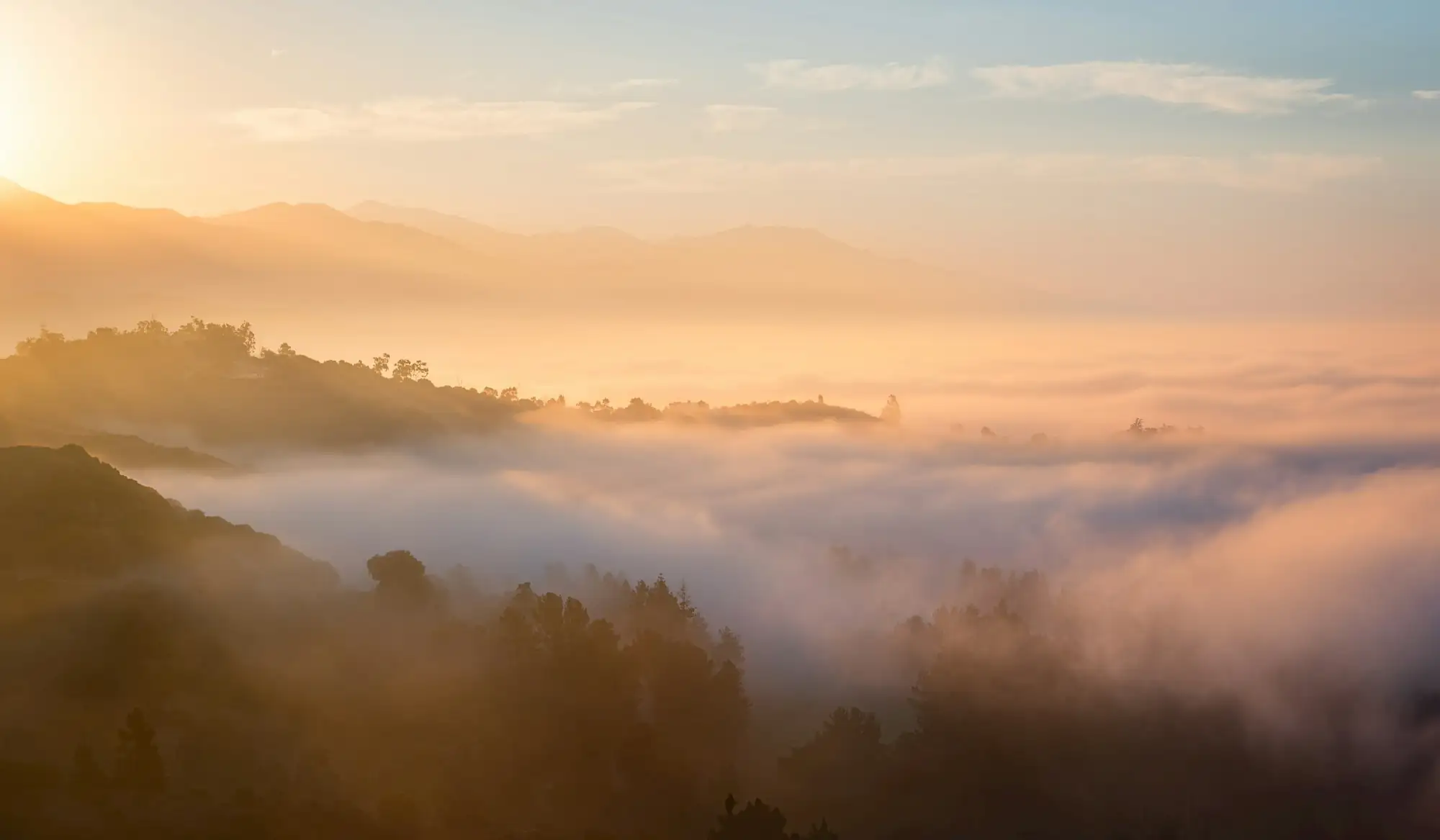 Goldenes Morgenlicht über einer nebligen Hügellandschaft